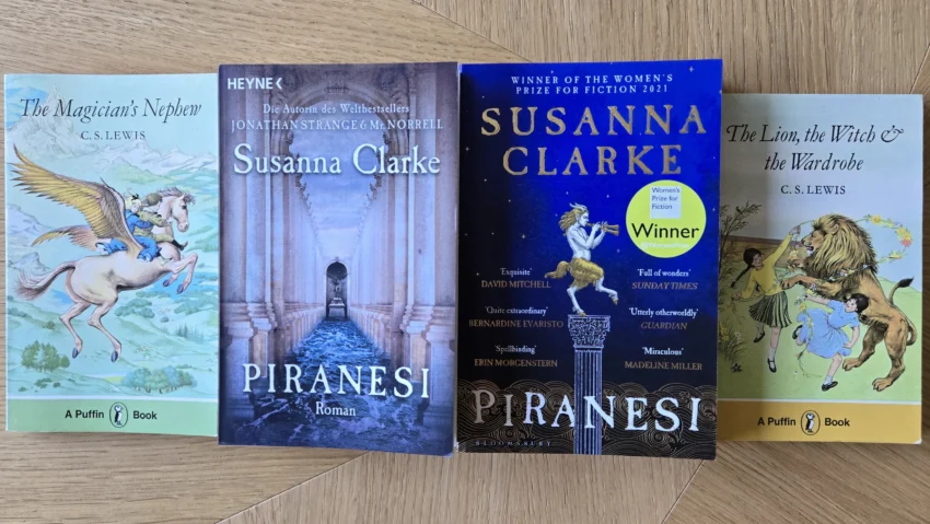 Das Bild zeigt vier Bücher, von links nach rechts: The Magician's Nephew von C. S. Lewis, die deutsche und die englische Ausgabe von Piranesi von Susanna Clarke, The Lion, the Witch and the Wardrobe von C. S. Lewis